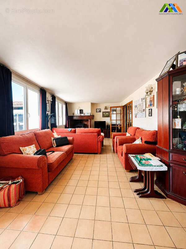 Living room with red sofas and wood-burning stove