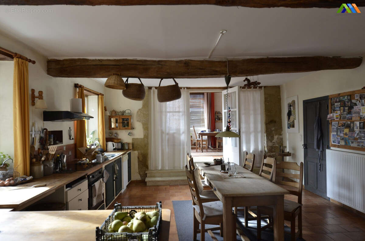Traditional kitchen and dining room with exposed beams and warm country-house character.