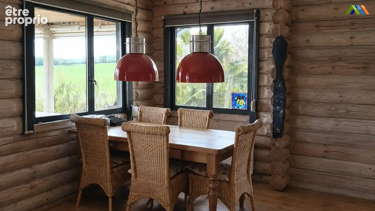 Dining area with wicker chairs, timber walls and views over the garden.