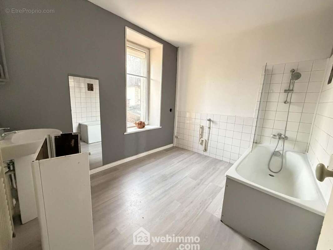 La salle de bains de 8 m² avec évier et une baignoire/douche - Appartement à LAON