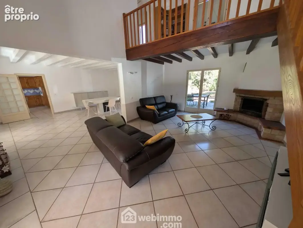 Pièce de vie de plus de 50m² avec cheminée et accès terrasses Nord et Sud