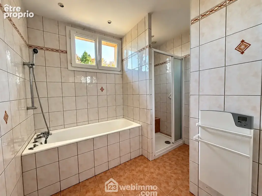 Une SDB avec baignoire, douche.