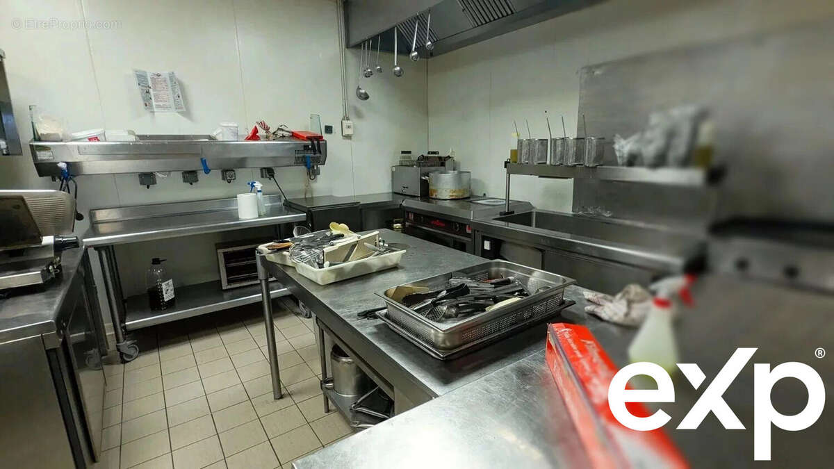 C'est une cuisine professionnelle avec des comptoirs en acier inoxydable, des équipements de cuisson, et des ustensiles. - Autre à AGEN