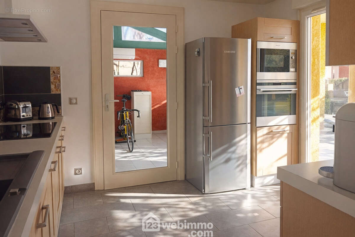 Cuisine toute aménagée et offrant accès à terrasse, traversante elle s'ouvre vers la pièce du SPA - Maison à LE THORONET