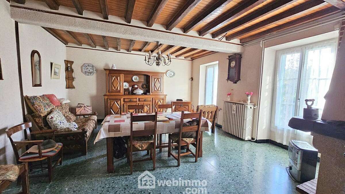 Voici le séjour de 28 m² avec ses poutres apparentes.
