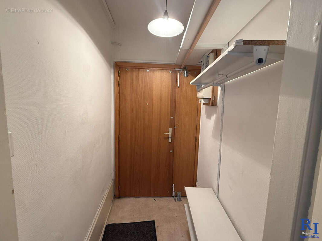 Entrée avec rangements ; porte en bois pleine - Appartement à GRENOBLE