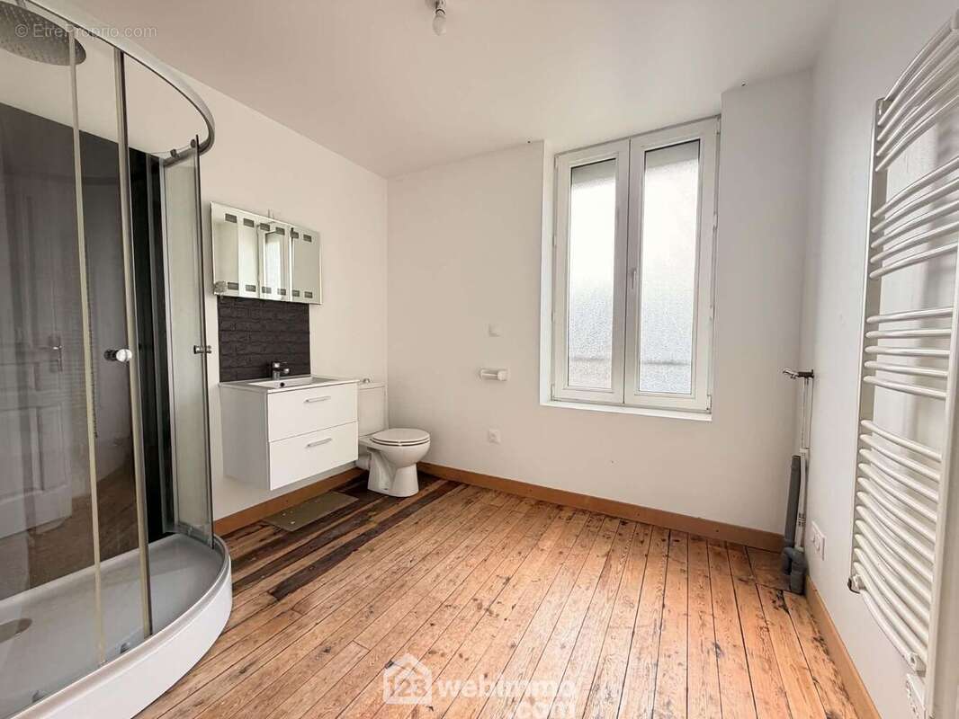 La salle de bains avec vasque sur meuble, une douche, un radiateur sèche serviettes et un wc - Maison à LAON