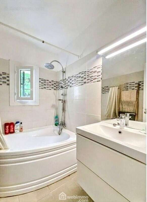 Salle de bains spacieuse et fonctionnelle avec baignoire et nombreux rangements. - Maison à SAINTE-MAXIME