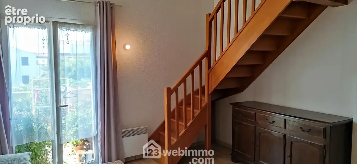 Pièce de vie avec escalier bois 1/4 tournant.