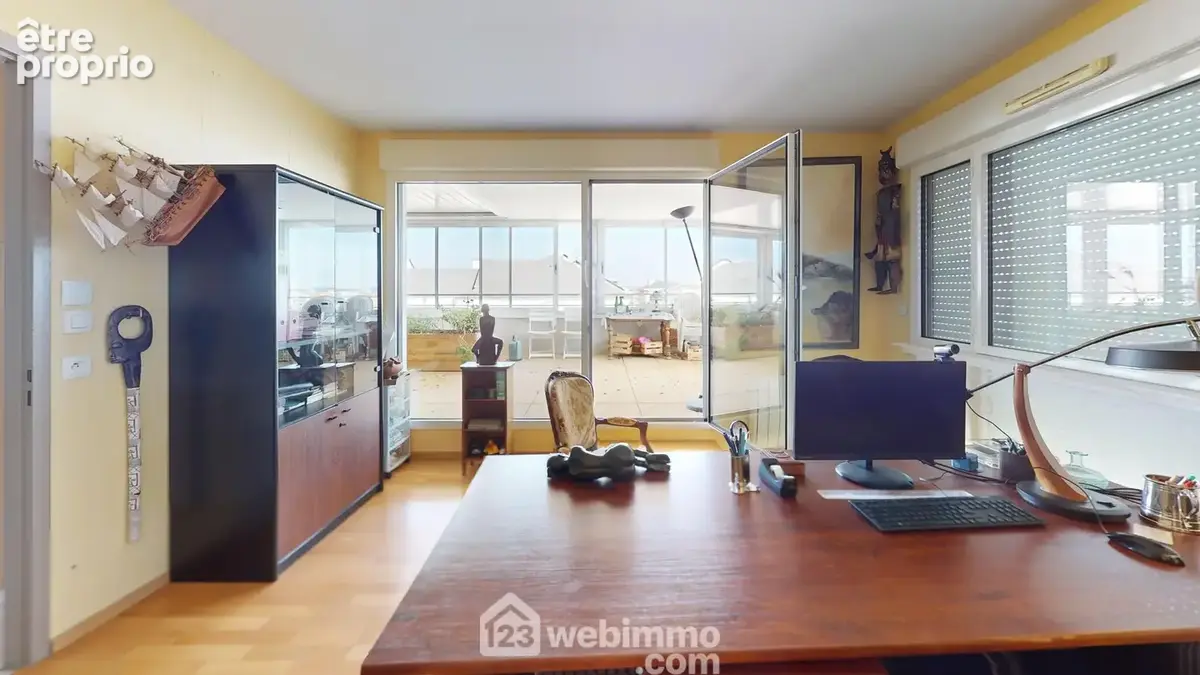 Bureau avec ouverture sur une terrasse couverte.